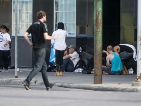 A group of people sit outside The Lighthouse in Saskatoon on Aug. 21, 2020.