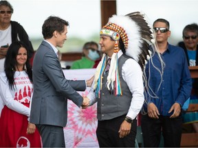 Cowessess First Nation Chief Cadmus Delorme, right, shakes hands with Prime Minister Justin Trudeau during an event surrounding the signing of a document, marking the transfer of control of children in care to the First Nation on July 6, 2021.