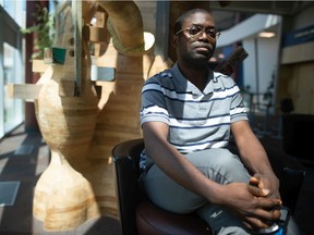 Taiwo Afolabi sits inside the University of Regina, where he completes his research on the intersection between arts and social issues.