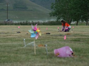 Chloe Golden, a teacher from Regina's Miller Comprehensive Catholic High School, lays flowers at the site where hundreds of unmarked graves were found on Cowessess First Nation in Saskatchewan on July 8, 2021.