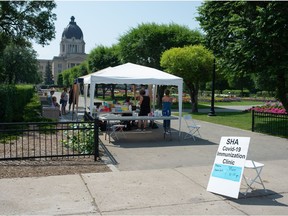 People attend a COVID-19 vaccine clinic held in the Queen Elizabeth II flower garden just north of the Saskatchewan Legislative Building in Regina, Saskatchewan on July 14, 2021.