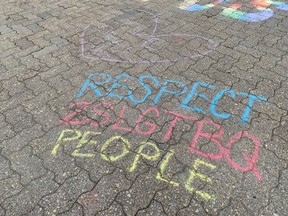 Phrases in support of a conversion therapy ban were drawn in chalk by community members outside Regina City Hall in advance of a city council meeting on July 14, 2021.