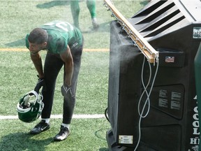 Saskatchewan Roughriders defensive back Jeremy Clark cools off by the water misting machine during Thursday's practice at Mosaic Stadium.

BRANDON HARDER/ Regina Leader-Post