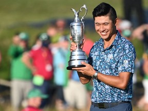 US golfer Collin Morikawa poses for pictures with the Claret Jug, the trophy for the Champion Golfer of the Year, after winning the 149th British Open Golf Championship at Royal St George's, Sandwich in south-east England on July 18, 2021.