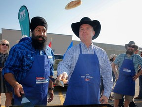 Conservative Leader Erin O'Toole flips a pancake at a pancake breakfast at the Calgary Stampede on July 10, 2021.