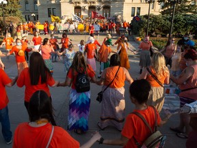 People participate in a round dance during a Canada Day vigil for the discovery of unmarked graves at First Nations in Canada.