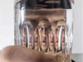 Kathy Donovan, a Cathedral resident with major concerns about the City of Regina's approach to lead service connections, looks through a glass of water.