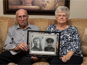Tom Jenkins, left, and his sister Margaret Schaffer sit together holding a photograph of their late uncle Morgan Jones Jenkins, a man who served during the First World War, in Regina, Saskatchewan on August 23, 2021. Morgan was listed missing in action in France, but his remains were recently identified.