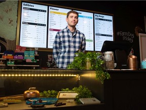 John Thomas, co-founder of BudSense, stands behind the counter in front of the menu board at Farmer Jane Cannabis Co. on McCarthy Boulevard in Regina, Saskatchewan on August 27, 2021. BudSense is a Regina-Calgary tech startup that helps cannabis stores create print, digital and web menus.