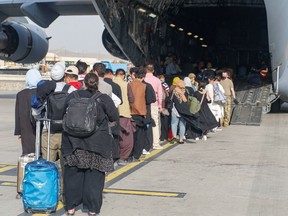 Evacuees board a C-17 Globemaster III during an evacuation at Hamid Karzai International Airport, Afghanistan, in this photo taken on Aug. 18.