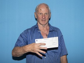 Montrealer Émile Cyr holds his 6/49 cheque.