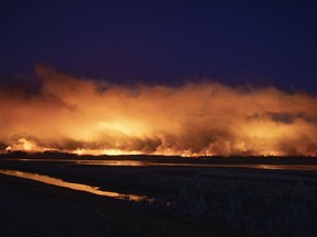 A forest fire burns late into the evening northeast of Prince Albert, on May 17, 2021.