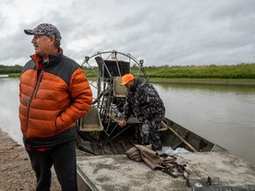 Gary Carriere looks on as his son Gary Jr. prepares their air boat to head out on the North Saskatchewan River. Photo taken near Cumberland House on Aug. 24, 2021.