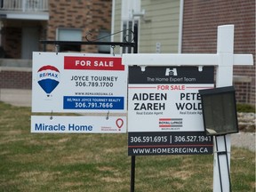 This file photo shows sale signs placed on a property park on Angus Street in Regina, Saskatchewan on May 6, 2020. A recent report indicates that the Saskatchewan housing market is 
