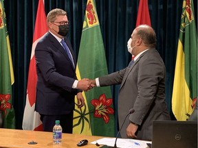 Premier Scott Moe and chief medical health officer Dr. Saqib Shahab shake hands at their last in-person press conference together in early July.