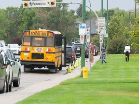 A school bus unloads kids at Jack Mackenzie School on the first day of classes in Regina, Saskatchewan on September 1, 2021.