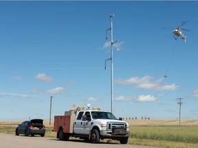 This Leader-Post file photo shows a helicopter stringing rope between large power line structures on the north end of Regina, Saskatchewan on Sept. 2, 2021. The line is part of SaskPower's Condie to Evraz Transmission line. SaskPower has made an application to expand its transmission line capacity between Saskatchewan and the U.S.