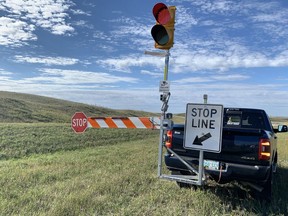 At an event in a rural area near Moose Jaw Sept. 7, 2021, the Saskatchewan Ministry of Highways shows off a new pilot project using remote-controlled "Guardian Angel" automatic flagging assistance devices (AFAD), which are operating in work zones this construction season. The truck-mounted, remote-controlled devices allow the flag person to be off the roadway while controlling traffic, minimizing their risk of injury.