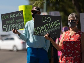 People rallied in front of Health Minister Paul Merriman's office in Saskatoon on Sept. 8, 2021, urging the Saskatchewan government to implement restrictions to limit the fourth wave of the COVID-19 pandemic.