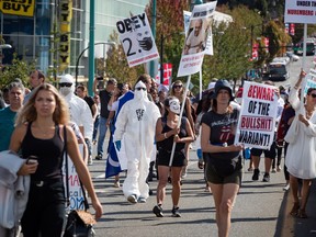 People march during a protest against COVID-19 vaccine passports and mandatory vaccinations for healthcare workers in Vancouver on Sept. 1. (Darryl Dyck / The Canadian Press)