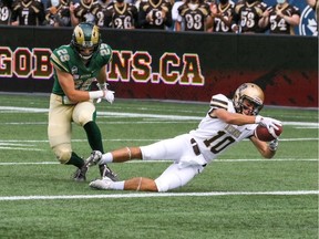 Kai Madsen of the University of Manitoba Bisons dives across the goal line to complete a 51-yard touchdown reception on Saturday against the visiting University of Regina Rams.