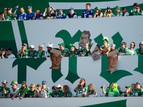 Saskatchewan Roughriders fans hold large cutouts of Winnipeg Blue Bombers quarterback Zach Collaros (8) in the Pil Country section during a CFL football game at Mosaic Stadium in Regina, Saskatchewan on Sept. 5, 2021.