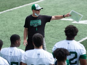 Head coach Craig Dickenson (centre) felt the Roughriders had a good practice Thursday after being forced indoors due to smoky weather conditions.