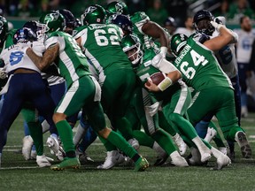 Saskatchewan Roughriders quarterback Cody Fajardo (7) leans on his team mates as they press forward on a short yardage play during Friday's game against the Toronto Argonauts.