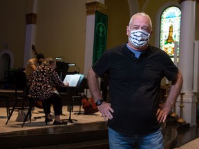 Regina Symphony Orchestra executive director Mike Forrester stands in front of a group of musicians during a rehearsal at the Holy Rosary cathedral on Sept. 14, 2021.