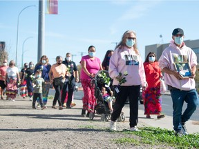People participate in the Sisters in Spirit Walk in Regina, Saskatchewan on Oct. 4, 2021. The walk to honour missing and murdered Indigenous women and girls began just north of the Regina Police Service headquarters on Osler Street, made its way through the city and ended at the Place of Reflection near the RCMP Heritage Centre.