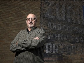 Rob Deglau, former city councillor, member of the warehouse district community, stands in front of a faded mural on the side of Harry's Hi-Fi. on Friday, October 8, 2021 in Regina.