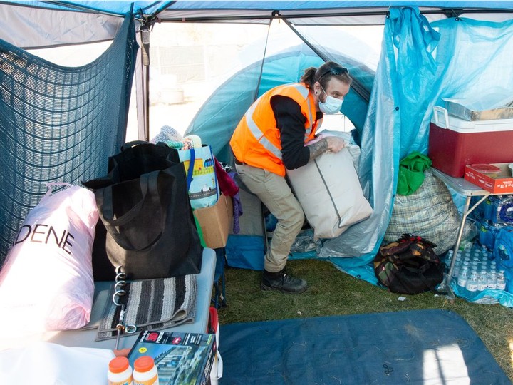  Volunteer Ian Betz-Wood pulls a package of bedding from inside a supply tent at Camp Marjorie, a tent encampment for homeless people, in Pepsi Park in Regina, Saskatchewan on Oct. 18, 2021. Bedding and tents are provided for those who need to use the camp.