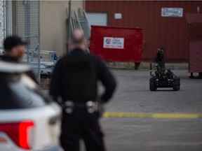 Regina Police Service members watch the Explosives Disposal Unit (EDU) robot while attending a call after a suspicious package was found at a location on First Avenue.