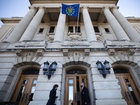 A security guard lets a woman in the front door of the Saskatchewan Legislative Building on the first day of the fall legislative sitting.