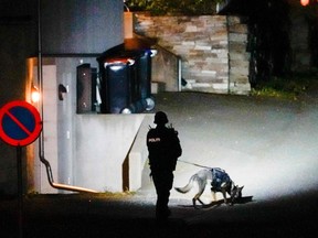 A police officer uses a sniffer dog at the scene they were investigating in Kongsberg.