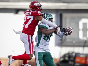 Saskatchewan Roughriders' Ricardo Louis, right, has a pass swatted away by Calgary Stampeders' Jonathan Moxey during first half of Saturday's game at McMahon Stadium.