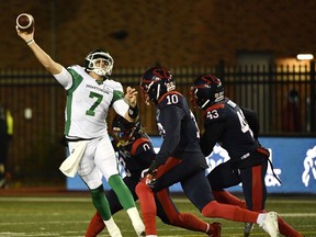 Saskatchewan Roughriders quarterback Cody Fajardo (7) passes the ball despite the pressure by Montreal Alouettes defensive lineman Nick Usher during the first quarter of Saturday's CFL game.