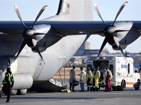 Medical personnel load a patient onto a Royal Canadian Air Force CC-130J Hercules transport aircraft, after the province of Saskatchewan said it would be sending COVID patients from overloaded ICU wards to Ontario hospitals, in Saskatoon, Saskatchewan, Canada October 28, 2021.