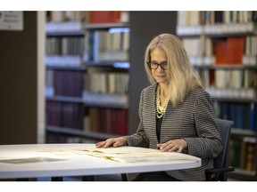 Carol Radford-Grant sits at a table in the Provincial Archives of Saskatchewan.