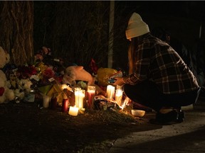A woman lights a candle at a vigil for a 16-year-old girl who died Nov. 1 in what is now being investigated as a homicide. The vigil was held in front of the home where the girl died on the 1200 block of Rae Street in Regina on Nov. 4, 2021.