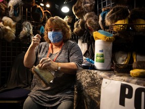 Roxane Ueland finishes up some sewing on a set of moccasins she's making to add to her display of fur and animal hide goods being sold at the Our Best To You Handmade Market at Evraz Place in Regina, Saskatchewan on Nov. 12, 2021.