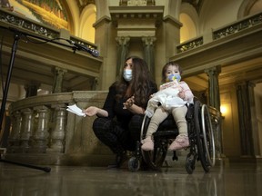 Sarah Turnbull is joined with her two-year-old daughter Blake as she speaks with reporters at the Legislative Building on Thursday, Nove. 18, 2021 in Regina.