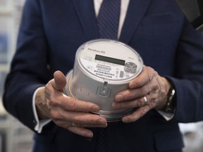 Minister Don Morgan holds a SaskPower's smart meter in the Saskatchewan Science Centre Lobby on Monday, November 22, 2021 in Regina.  The update included information on the upcoming deployment to residences across Saskatchewan.