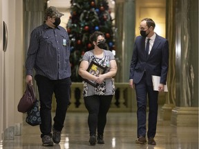 Stephanie Brad and her husband Mike speak with NDP leader Ryan Meili at the Legislative Building after speaking with reporters about her cancelled surgeries. Brad held a photo of her four daughters while speaking at the Legislative Building.