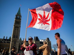 FILE - A woman waves a flag with a marijuana leaf in celebration of National Marijuana Day on Parliament Hill in Ottawa.