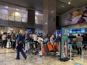 Passengers in South Africa queue to check in for a flight on Singapore Airlines at O.R. Tambo International Airport in Johannesburg, South Africa, November 26, 2021. REUTERS/ Sumaya Hisham