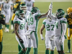 Saskatchewan Roughriders' Brayden Lenius (19), D'haquille Williams (14) high five as they celebrate their touchdown with Ricardo Louis (86) Brett Boyko (68) and Kienan LaFrance (27) while Edmonton Elks' Jonathan Rose (0) and Aaron Grymes (36) leave the field during first half CFL action in Edmonton on Friday, November 5, 2021.
