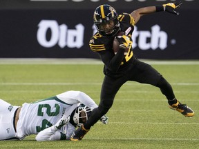 Hamilton Tiger Cats wide receiver Tim White (12) gets away from Saskatchewan Roughriders defensive back Damon Webb (24) during first half CFL action in Hamilton on Saturday.