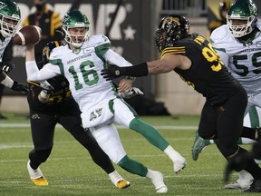 Saskatchewan Roughriders quarterback Isaac Harker, 16, is pressured by Hamilton Tiger Cats defensive linemen Dylan Wynn, 98, and Julian Howsare, 95, on Saturday at Tim Hortons Field.