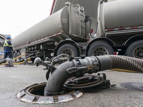 A fuel delivery driver fills up the tanks of a gas station in Burnaby on Nov. 20.